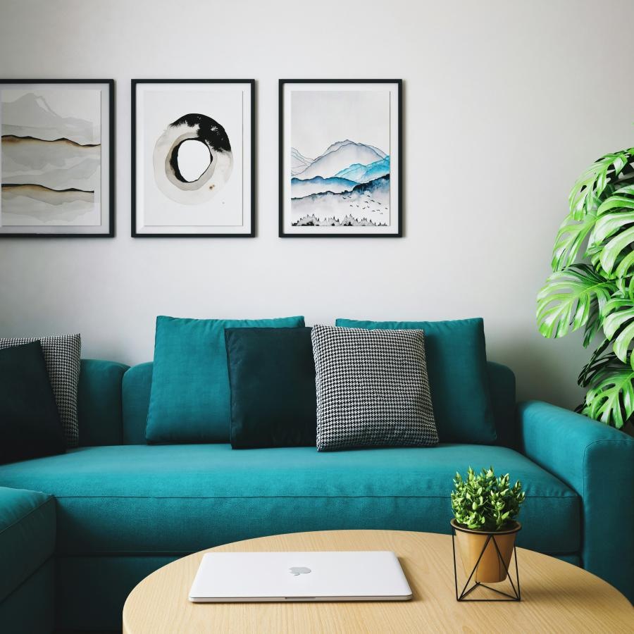 a blue couch with a table and a plant on the side