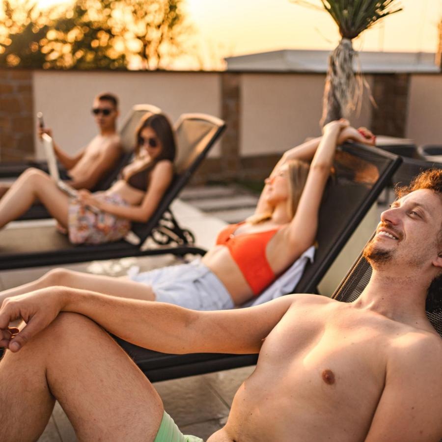 a group of people sitting in lounge chairs on a patio